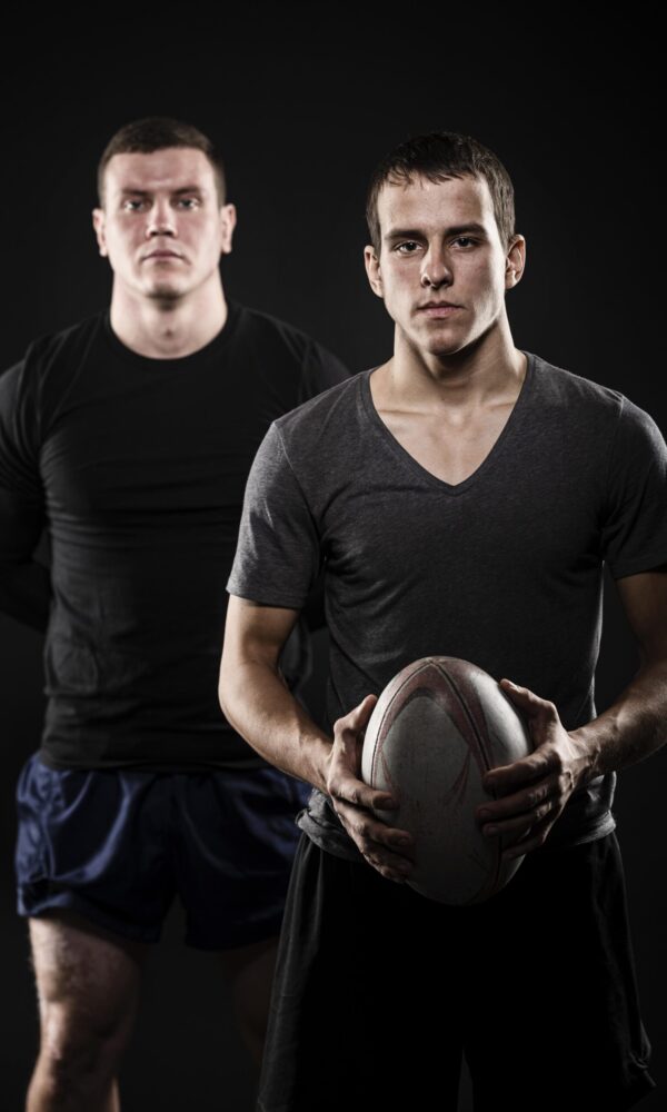 front-view-male-rugby-players-posing-with-ball